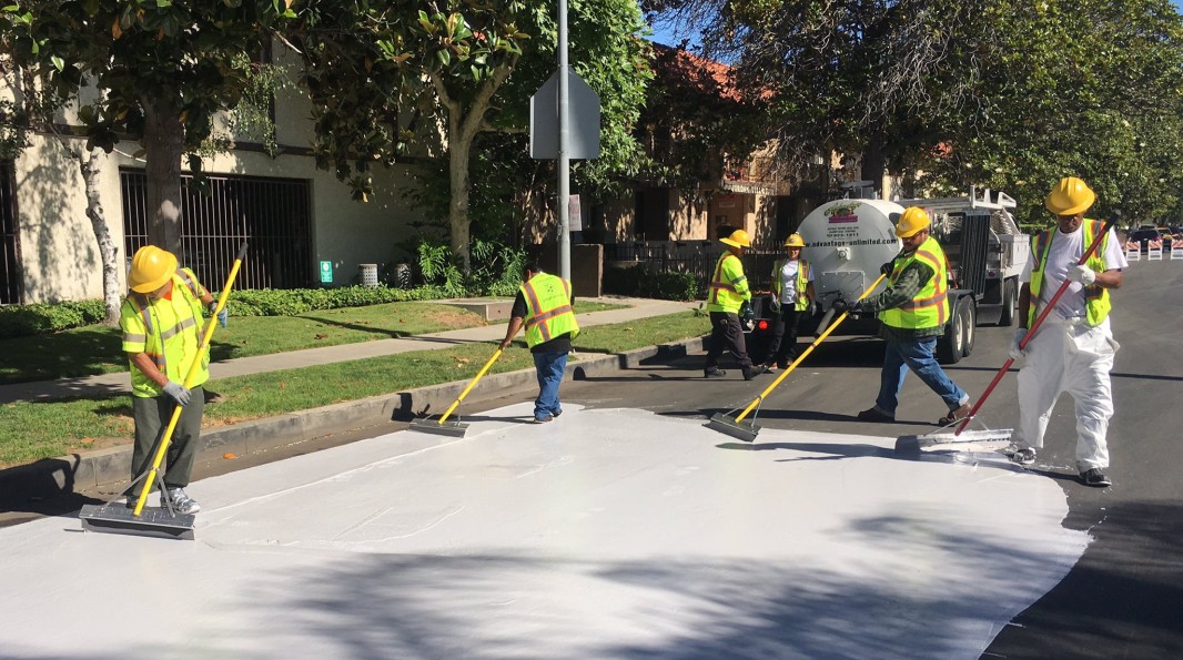 Ouvriers à Los Angeles recouvrant une rue de peinture blanche